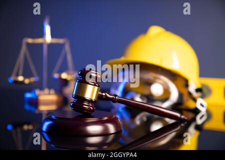 Concetto di legge di costruzione. Casco e Gavel del giudice su sfondo grigio. Foto Stock