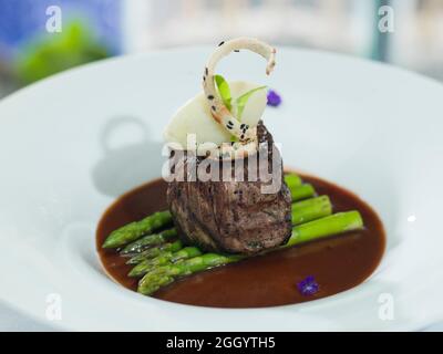 Gustoso filetto mignon su un letto di asparagi in salsa al pepe nero. Foto Stock