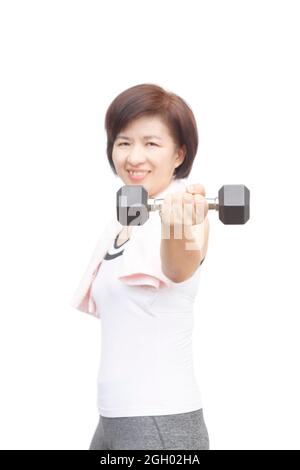 Fitness sano metà età asiatica donna sorridente felice sollevamento pesi Foto Stock