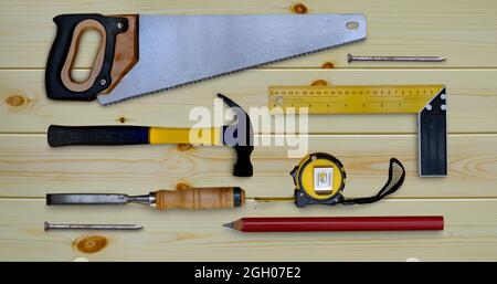 Metro a nastro per sega a martello prova la collezione di utensili per lavorazione del legno a matita quadrata e scalpello su un banco di lavoro in legno Foto Stock