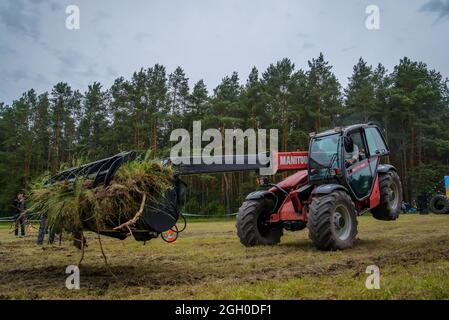 Cherkasy, Ucraina - 16 giugno 2015: Lavoro sul caricatore rosso Manitou esegue trucchi. Guida sulle ruote anteriori Foto Stock