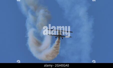 Ferrara Italia 27 GIUGNO 2021 Vintage aereo vola nel cielo blu con fumo bianco. Speciale Christen Pitts S-2B Foto Stock