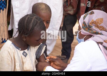 Operatore medico che effettua vaccinazioni di routine per i bambini in Africa Foto Stock