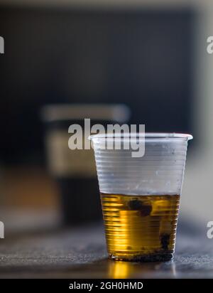 Posacenere in vetro nero con mozziconi di sigaretta, mozziconi con cenere isolata su sfondo bianco, vista dall'alto Foto Stock