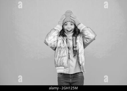 il bambino sorpreso in giacca e maglieria in puffer d'argento si scalda in inverno pronto per l'attività in vacanza, spazio copia, felicità d'infanzia Foto Stock