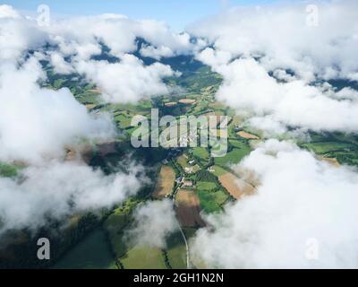VISTA AEREA. Villaggio di Percy circondato da nuvole a bassa quota al mattino. Regione di Trièves, Isère, Francia. Foto Stock