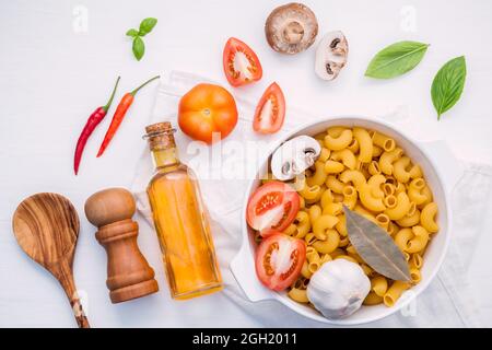 Cibi italiani del concetto e del design del menu . Pasta pasta tipo gramigna con ingredienti basilico dolce ,il pomodoro , Aglio , Olio di oliva extra vergine , Prezzemolo , bay lasciare Foto Stock