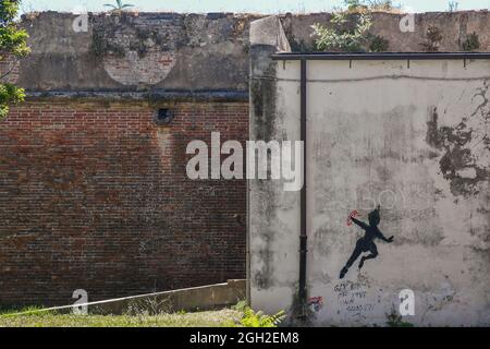 Un graffito raffigurante la silhouette di Peter Pan in flyght su un vecchio muro nel quartiere di New Venice, Livorno, Toscana, Italia Foto Stock