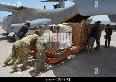 Marines degli Stati Uniti, marinai e volontari caricano le forniture alimentari su un aereo MV-22 Osprey durante una missione umanitaria 4 settembre 2021 a Port-au-Prince, Haiti. I militari, l'USAID e i volontari stanno assistendo nel periodo successivo al recente terremoto. Foto Stock