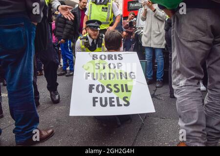 Londra, Regno Unito. 4 settembre 2021. La polizia parla con un manifestante che blocca la strada. Un paio di manifestanti della ribellione di estinzione hanno bloccato il traffico su Oxford Street l'ultimo giorno della loro campagna di ribellione impossibile di due settimane, chiedendo al governo britannico di agire in modo significativo sulla crisi climatica ed ecologica. (Credit: Vuk Valcic / Alamy Live News) Foto Stock