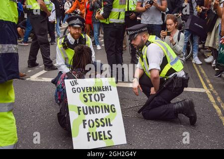 Londra, Regno Unito. 4 settembre 2021. La polizia parla con un manifestante che blocca la strada. Un paio di manifestanti della ribellione di estinzione hanno bloccato il traffico su Oxford Street l'ultimo giorno della loro campagna di ribellione impossibile di due settimane, chiedendo al governo britannico di agire in modo significativo sulla crisi climatica ed ecologica. (Credit: Vuk Valcic / Alamy Live News) Foto Stock
