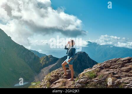 ragazza si alza sulla montagna con le braccia tese Foto Stock