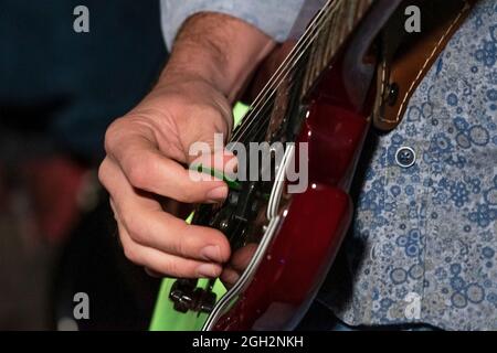 Dettaglio della mano di una persona che suona una chitarra elettrica. Scheda per chitarra elettrica. Foto Stock