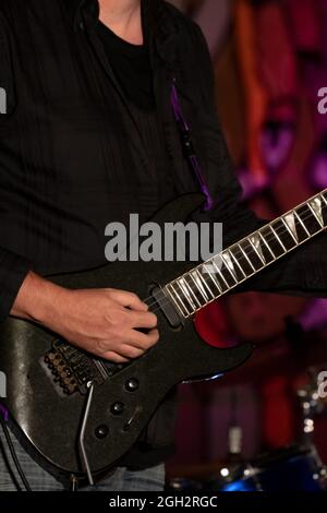 Dettaglio della mano di una persona che suona una chitarra elettrica. Scheda per chitarra elettrica. Foto Stock