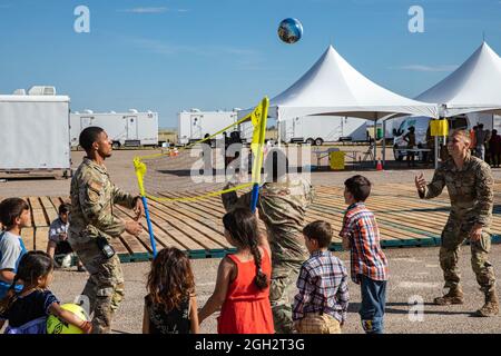 Airmen assegnati alla Task Force - Holloman gioca una partita di pallavolo con il personale afghano più giovane durante il loro soggiorno alla base dell'aeronautica di Holloman, New Mexico, 3 settembre 2021.The Department of Defense, attraverso il comando del Nord degli Stati Uniti, E a sostegno del Dipartimento di Stato e del Dipartimento di sicurezza interna, sta fornendo trasporto, alloggio temporaneo, screening medico, e il sostegno generale per almeno 50,000 sfollati afghani in strutture adeguate, in strutture permanenti o temporanee, il più rapidamente possibile. Questa iniziativa fornisce agli evacuati afghani un sostegno essenziale in luoghi sicuri al di fuori di essa Foto Stock