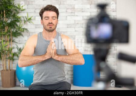 giovane uomo yoga che registra sport yoga blog sulla fotocamera Foto Stock