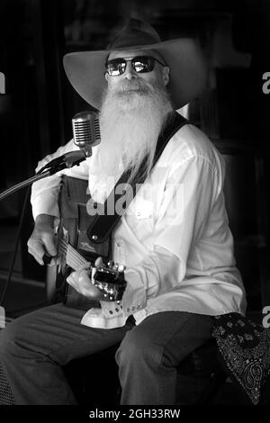 Johnny Lloyd, noto artista di strada a Santa Fe, New Mexico, si esibisce su un marciapiede che si affaccia sulla storica piazza della città. Foto Stock