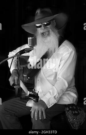 Johnny Lloyd, noto artista di strada a Santa Fe, New Mexico, si esibisce su un marciapiede che si affaccia sulla storica piazza della città. Foto Stock