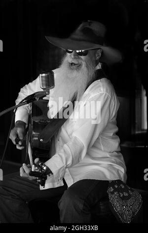 Johnny Lloyd, noto artista di strada a Santa Fe, New Mexico, si esibisce su un marciapiede che si affaccia sulla storica piazza della città. Foto Stock