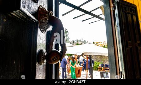 antica porta in legno con campana a mulinello Foto Stock