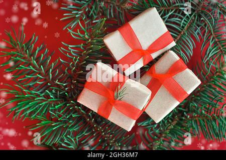 regali di natale su albero sempreverde e sfondo rosso Foto Stock