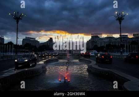 Bucarest, Romania - 02 settembre 2021: Tramonto attraverso le nuvole di tempesta sopra le fontane da Piazza Unirii, a Bucarest. Foto Stock