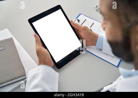 Medico di sesso maschile che tiene il tablet digitale in mano guardando bianco mockup schermo. Foto Stock
