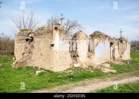 Vecchia casa rovinata. Rovine di una casa fatta di roccia conchiglia, paglia e argilla nel villaggio. Povero vecchio villaggio. Foto Stock