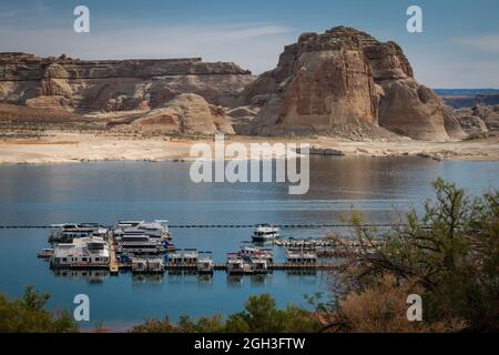 Barche ormeggiate sul lago Powell, Utah, con scogliere di arenaria e spiaggia sullo sfondo Foto Stock