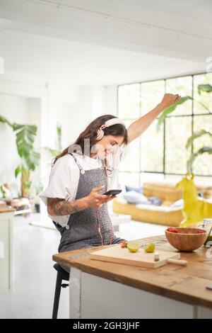 Giovane e gioioso vincitore a casa per celebrare il concetto di vittoria mobile. Studente euforico che riceve un messaggio sms leggendo buone notizie. Felice donna eccitato Foto Stock