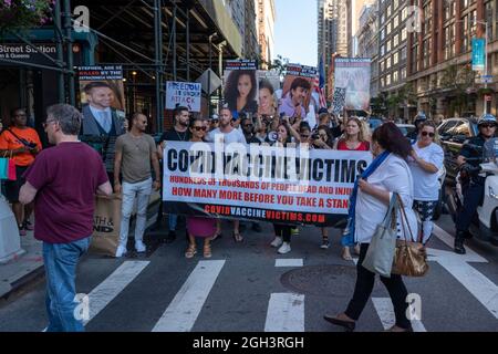 NEW YORK, NY - SETTEMBRE 04: I pedoni in un crosswalk guardano i manifestanti anti anti-vaccinazione durante una marcia per le strade del centro ad un raduno della libertà contro i mandati di vaccinazione il 04 Settembre 2021 a New York City. Credit: Ron Adar/Alamy Live News Foto Stock