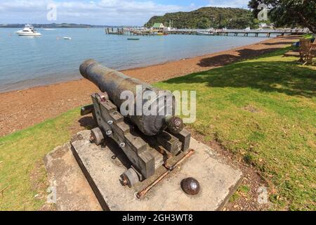 Russell, una città della Baia delle Isole, Nuova Zelanda. Il vecchio cannone sulla spiaggia fu usato per difendere la città nel 1840 Foto Stock