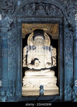 Statua di un grande Buddha seduto in elaborato santuario con intricato telaio porta, Ajanta Cave 6, Maharashtra, India Foto Stock