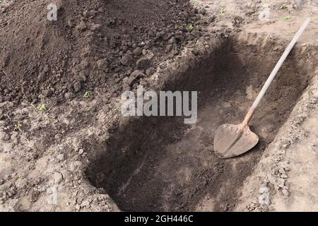 Scavando una buca. Buca nella terra. La pala nella fossa. Foto Stock