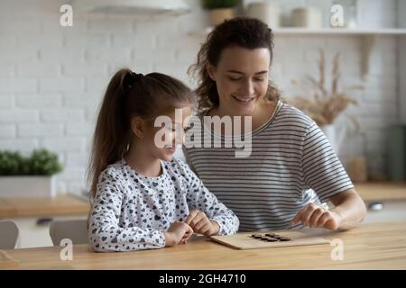 Felice fidanzato mamma e figlia bambino godendo in gioco da tavolo Foto Stock