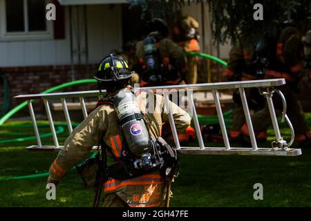 Reno, Stati Uniti. 4 settembre 2021. Un vigile del fuoco fa funzionare una scala ad una casa con il fumo che viene dal roof.Firefighters ha funzionato per mettere fuori ed il fuoco dell'attico in una casa singola della famiglia. La causa è ancora sotto esame. (Foto di Ty o'Neil/SOPA Images/Sipa USA) Credit: Sipa USA/Alamy Live News Foto Stock