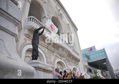 Non esclusiva: TUNISIA CITY, TUNISIA - 4 SETTEMBRE: Un uomo detiene una bandiera mentre prendono parte a una manifestazione contro la visita del deleg americano Foto Stock