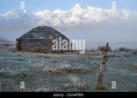 Vista sul pastore della casa di vela e Altai lago Dzhangyskol sul altopiano di montagna Eshtykel. La cresta di Chui Nord è sullo sfondo. Nebbia mattutina sull'acqua. Altai Foto Stock