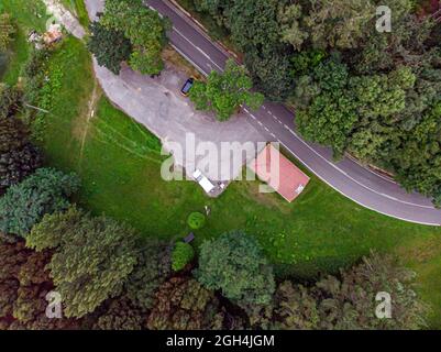 Una vista aerea di una strada stretta e lunga circondata da alti alberi verdi Foto Stock
