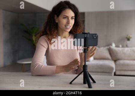 Sorridente donna ispanica registrazione video su cellulare web camera. Foto Stock