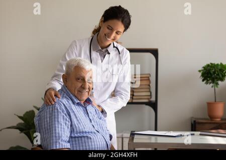 Ritratto di felice medico GP femmina dando speranza, sostegno Foto Stock