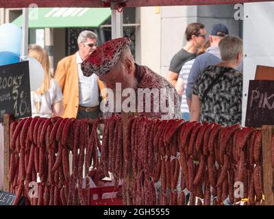 Sint Gillis WAAS, Belgio, 04 settembre 2021, uomo con barba bianca grande e cappello su vende salsicce fatte a mano al mercato locale Foto Stock