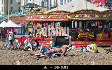 Brighton UK 5 settembre 2021 - Brighton Beach è occupato come i visitatori godere del sole come il tempo caldo è previsto per continuare nei prossimi giorni in Gran Bretagna con temperature previste per raggiungere gli alti 20 centigradi in alcune zone : Credit Simon Dack / Alamy Live News Foto Stock