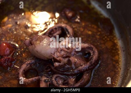Una padella piena di salsa di mare con polpo Foto Stock