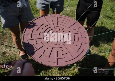 Gioco di teambuilding per gruppi di persone per ottenere lo spirito di squadra e aumentare l'amicizia per i colleghi. Labirinto gioco per gruppo di persone. Foto Stock