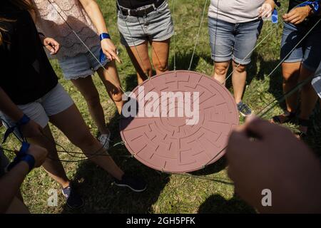 Gioco di teambuilding per gruppi di persone per ottenere lo spirito di squadra e aumentare l'amicizia per i colleghi. Labirinto gioco per gruppo di persone. Foto Stock