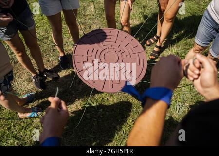 Gioco di teambuilding per gruppi di persone per ottenere lo spirito di squadra e aumentare l'amicizia per i colleghi. Labirinto gioco per gruppo di persone. Foto Stock