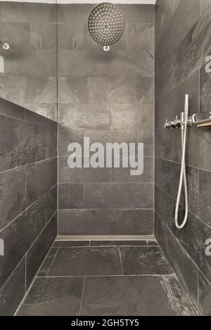 Interno di un bagno moderno con pareti grigie e pavimento disegnato in stile minimalista Foto Stock