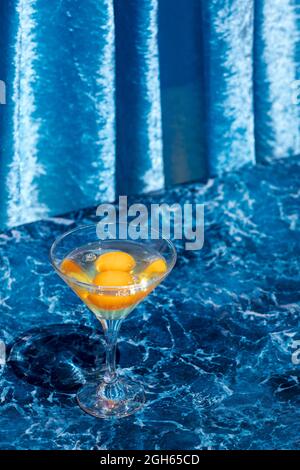 Dall'alto di calice di vetro con uova crude poste su un tavolo di marmo che mostra il concetto di nascita della vita Foto Stock