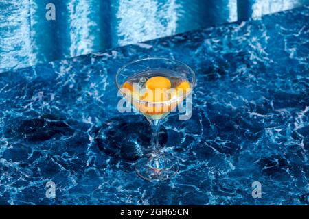 Dall'alto di calice di vetro con uova crude poste su un tavolo di marmo che mostra il concetto di nascita della vita Foto Stock